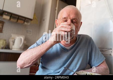 Homme âgé de 80 ans à la maison prenant des pilules à la maison, portrait en gros plan. Retraite heureuse et saine avec soins médicaux Banque D'Images