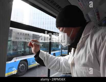 200127 -- BEIJING, le 27 janvier 2020 -- Un membre du personnel marque l'heure de désinfection dans un bus à une gare routière de Beijing, capitale de la Chine, le 27 janvier 2020. La Beijing public transport Corporation a pris des mesures telles que la désinfection des bus, la mesure des températures des membres du personnel et la garantie que le personnel travaille avec des masques faciaux pour prévenir la propagation du nouveau coronavirus. CHINE-PÉKIN-CORONAVIRUS-TRANSPORTS PUBLICS-PRÉVENTION CN RENXCHAO PUBLICATIONXNOTXINXCHN Banque D'Images