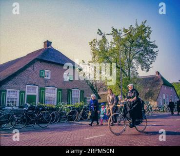 Pays-Bas, Staphorst, les femmes sur leur chemin à l'église sur un bycicle en costume traditionnel. Banque D'Images