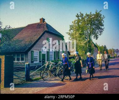 Pays-Bas, Staphorst, des hommes et des femmes en chemin vers l'église en costume traditionnel. Banque D'Images