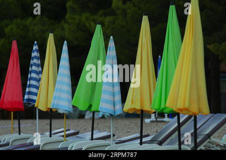 Parasols colorés sur la plage se préparant pour l'été en Croatie Banque D'Images