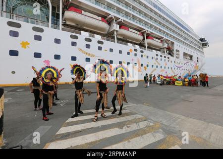 Fête de bienvenue sur le thème de la fête philippine pour bateau de croisière à Manille Pier : musiciens avec des instruments en bambou, danseurs philippins, higantes, drapeaux Banque D'Images