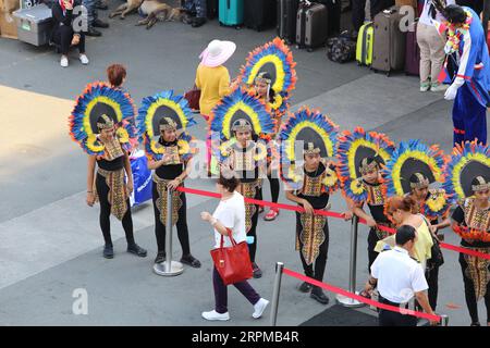 Fête de bienvenue sur le thème de la fête philippine pour bateau de croisière à Manille Pier : musiciens avec des instruments en bambou, danseurs philippins, higantes, drapeaux Banque D'Images