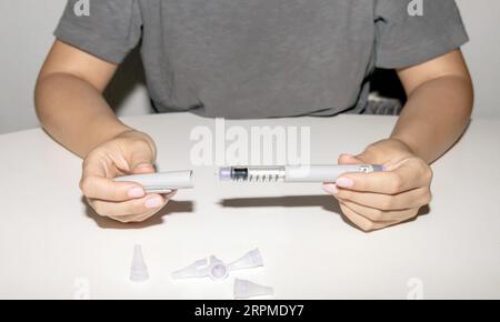 Mains féminines tenant un stylo à insuline. Stylo injecteur d'insuline Lantus ou stylo cartouche d'insuline pour diabétiques. Matériel médical pour les parients diabétiques. Banque D'Images