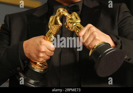 200210 -- LOS ANGELES, 10 février 2020 -- Bong Joon-ho tient les Oscars remportés par parasite lors de la 92e cérémonie des Oscars au Dolby Theatre de Los Angeles, aux États-Unis, le 9 février 2020. La comédie noire sud-coréenne parasite s'est avérée être le plus grand gagnant de la 92e cérémonie des Oscars dimanche soir. Outre Nabbing Best Picture, le thriller de classe de genre a également remporté le prix du meilleur réalisateur pour Bong Joon-ho, du meilleur long métrage international et du meilleur scénario original. Parasite est également entré dans l'histoire aux 92nd Academy Awards en devenant le premier film en langue étrangère à remporter le meilleur pictu Banque D'Images