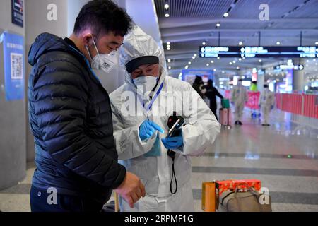 200211 -- XI AN, le 11 février 2020 -- Un membre du personnel aide un passager à enregistrer des informations à la gare ferroviaire nord de Xi an à Xi an, dans la province du Shaanxi du nord-ouest de la Chine, le 10 février 2020. Avec l'augmentation du flux de passagers dans divers centres de transport, Xi an a lancé un système de gestion de réseau pour les personnes qui viennent à Xi an. Toutes les personnes entrant à Xi an par l'aéroport international de Xianyang, la gare ferroviaire de Xi an, la gare ferroviaire du Nord de Xi an, la gare ferroviaire du Sud de Xi an, la gare ferroviaire de Huyi et la gare ferroviaire du Palais d'Epang doivent être classées et filtrées une par une pour assurer une prévention précise et co Banque D'Images