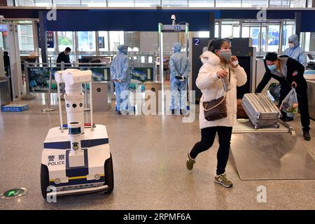 200211 -- XI AN, 11 février 2020 -- Un robot est utilisé par la police pour mesurer la température des passagers à une entrée de la gare ferroviaire nord de Xi an à Xi an, province du Shaanxi au nord-ouest de la Chine, 10 février 2020. Avec l'augmentation du flux de passagers dans divers centres de transport, Xi an a lancé un système de gestion de réseau pour les personnes qui viennent à Xi an. Toutes les personnes entrant à Xi an par l'aéroport international de Xianyang, la gare ferroviaire de Xi an, la gare ferroviaire du nord de Xi an, la gare ferroviaire du sud de Xi an, la gare ferroviaire de Huyi et la gare ferroviaire du palais d'Epang doivent être classées et filtrées une par une afin d'obtenir un résultat Banque D'Images