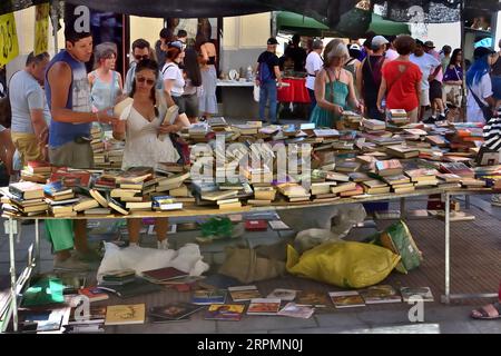 Madrid, Espagne - 20 août 2023 : les gens choisissent des livres sur le marché de rue. Ce marché de rue s’appelle El Rastro, il est le plus grand de Madrid et des milliers de personnes le visitent tous les dimanches. Banque D'Images
