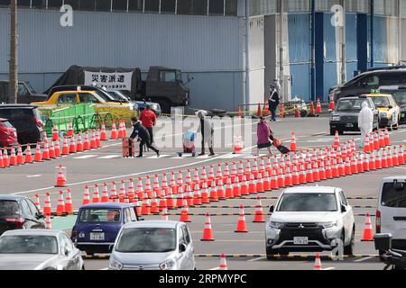 200219 -- YOKOHAMA, le 19 février 2020 -- les passagers partent avec leurs bagages après avoir débarqué du Diamond Princess , un navire de croisière maintenu en quarantaine au port de Yokohama au Japon, le 19 février 2020. Les passagers du nouveau navire de croisière Diamond Princess infligé par le coronavirus ont commencé à débarquer mercredi dans le port japonais de Yokohama après une période de quarantaine de deux semaines. Dans au moins trois jours, près de 3 000 personnes débarqueront du navire, qui a 542 cas confirmés du virus causant la pneumonie à ce jour, selon le gouvernement. Le premier groupe d'environ 500 principalement elderl Banque D'Images