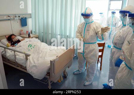 200220 -- WUHAN, 20 février 2020 -- Zhao Jianping C, spécialiste des soins respiratoires et des soins intensifs de l'hôpital de Tongji, basé à Wuhan, interroge un patient au service des cas graves de Wuhan, dans la province du Hubei, au centre de la Chine, le 18 février 2020. CHINA-WUHAN-NCP-CAS GRAVE WANGXYUGUO PUBLICATIONXNOTXINXCHN Banque D'Images