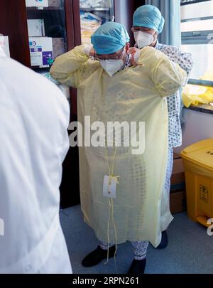 200220 -- WUHAN, 20 février 2020 -- Zhao Jianping 2nd R, spécialiste des soins respiratoires et des soins intensifs de l'hôpital de Tongji basé à Wuhan, porte une combinaison de protection avant d'entrer dans le service des cas graves de Wuhan, dans la province du Hubei du centre de la Chine, le 18 février 2020. CHINA-WUHAN-NCP-CAS GRAVE WANGXYUGUO PUBLICATIONXNOTXINXCHN Banque D'Images