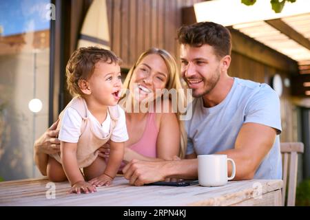 Famille Shot comme parents jouer avec Young son à la maison tout en utilisant la tablette numérique Banque D'Images