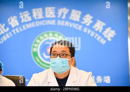 200223 -- XIAOGAN, le 23 février 2020 -- Liu Jinglun assiste à une téléconsultation entre le personnel médical de l'Hôpital de la première personne de Xiaogan et le premier hôpital affilié de l'Université médicale de Chongqing, dans la ville de Xiaogan, dans la province du Hubei, au centre de la Chine, le 19 février 2020. Liu Jinglun, 42 ans, médecin du premier hôpital affilié de l'Université de médecine de Chongqing, est arrivé à Xiaogan en tant que membre du premier groupe d'équipes médicales de Chongqing pour aider à lutter contre la nouvelle épidémie de COVID-19 à coronavirus dans le Hubei. En tant que chef d'équipe pour les cas graves, Liu déploie tous les efforts possibles, inc Banque D'Images