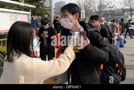 200225 -- XI AN, 25 février 2020 -- les nouveaux employés obtiennent leurs températures vérifiées avant d'entrer sur le campus du constructeur automobile BYD Auto à Xi an, province du Shaanxi au nord-ouest de la Chine, 25 février 2020. L'usine Xi a de BYD Auto a repris sa production dans le cadre des efforts de prévention et de contrôle des épidémies. CHINA-SHAANXI-XI AN-BYD-PRODUCTION REPRISE CN LIUXXIAO PUBLICATIONXNOTXINXCHN Banque D'Images