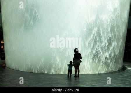 200227 -- SINGAPOUR, le 27 février 2020 Xinhua -- Un enfant et sa mère voient le vortex de pluie au Jewel Changi de Singapour le 27 février 2020. Xinhua/puis Chih Wey SINGAPOUR-VIE QUOTIDIENNE PUBLICATIONxNOTxINxCHN Banque D'Images