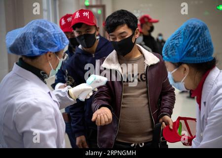 200228 -- GUYUANNINGXIA, le 28 février 2020 -- des travailleurs migrants font la queue pour attendre un test de température avant d'élargir un avion affrété dans la ville de Guyuan, dans la région autonome hui de Ningxia, au nord-ouest de la Chine, le 27 février 2020. Le premier lot de 142 travailleurs migrants de la ville de Guyuan à la province du Fujian est arrivé jeudi par vol affrété. CHINE-NINGXIA-FUJIAN-TRAVAILLEURS MIGRANTS-RETOUR AU TRAVAIL CN FENGXKAIHUA PUBLICATIONXNOTXINXCHN Banque D'Images