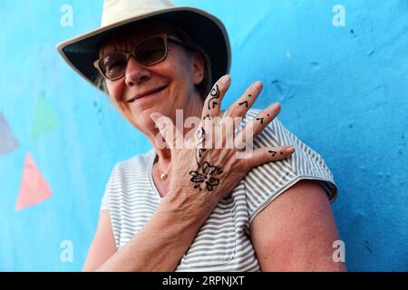 200301 -- ASSOUAN, le 1 mars 2020 -- Une femme montre ses tatouages au henné à Assouan, Égypte, le 12 février 2020. Dans les villages nubiens de la province de haute-Égypte d Assouan, près du Nil, il est courant de voir une touriste locale ou étrangère assise devant un artiste nubien au henné sur un trottoir à un bazar coloré ou à l'intérieur d'un café pour obtenir un tatouage au henné dessiné sur sa main. POUR ALLER AVEC la caractéristique : tatouages au henné nubien attirent les touristes locaux, étrangers dans le village Assouan EGYPTE-Assouan-NUBIAN TATOUAGES AU HENNÉ AhmedxGomaa PUBLICATIONxNOTxINxCHN Banque D'Images