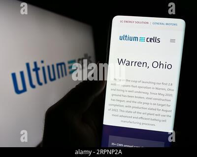 Personne détenant un téléphone portable avec le site Web de la société de batterie EV américaine Ultium Cells LLC sur l'écran devant le logo. Concentrez-vous sur le centre de l'écran du téléphone. Banque D'Images