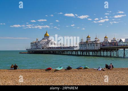 Paddleboards et touristes sur la plage par Eastbourne Pier à Eastbourne, East Sussex, Royaume-Uni en septembre Banque D'Images