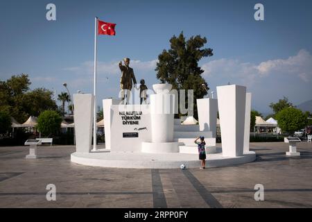 Un garçon regardant la statue de Mustafa Kemal AtatŸrk à Fethiye, Turquie. AtatŸrk (c. 1881 - 1938) était un maréchal turc, homme d'État révolutionnaire, auteur, et le père fondateur de la République de Turquie, servant en tant que premier président de 1923 jusqu'à sa mort en 1938. Il a entrepris des réformes progressistes radicales, qui ont modernisé la Turquie en une nation laïque et industrialisante. Banque D'Images