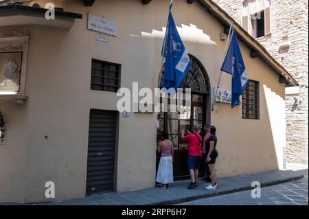 Un petit groupe guidé de touristes regarde à travers les fenêtres de la Bottega Del Opera Di Santa Maria Del Fiore (l'atelier ou le studio de l'Opéra de S. Banque D'Images