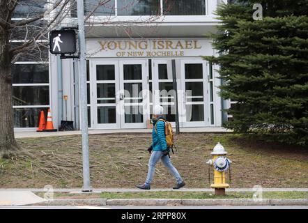 200312 -- NEW YORK, le 12 mars 2020 -- Une femme passe devant Young Israel, une synagogue au centre d'une zone de confinement d'un rayon d'un kilomètre à New Rochelle, État de New York, États-Unis, le 12 mars 2020. L’État américain de New York a mis en place une soi-disant zone de confinement dans un hotspot COVID-19 jeudi, avec des troupes de la Garde nationale envoyées sur place pour nettoyer les surfaces et livrer de la nourriture aux personnes en quarantaine. ÉTATS-UNIS-NEW YORK-NEW ROCHELLE- ZONE DE CONFINEMENT -COVID-19 WANGXYING PUBLICATIONXNOTXINXCHN Banque D'Images