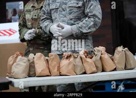 200312 -- NEW YORK, le 12 mars 2020 -- des membres de la Garde nationale distribuent de la nourriture à des résidents qualifiés près de la zone de confinement d'un kilomètre à New Rochelle, dans l'État de New York, aux États-Unis, le 12 mars 2020. L’État américain de New York a mis en place une soi-disant zone de confinement dans un hotspot COVID-19 jeudi, avec des troupes de la Garde nationale envoyées sur place pour nettoyer les surfaces et livrer de la nourriture aux personnes en quarantaine. ÉTATS-UNIS-NEW YORK-NEW ROCHELLE- ZONE DE CONFINEMENT -COVID-19 WANGXYING PUBLICATIONXNOTXINXCHN Banque D'Images