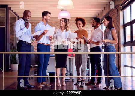 Femme d'affaires dirigeant l'équipe réunion dans le bureau multiculturel occupé Banque D'Images