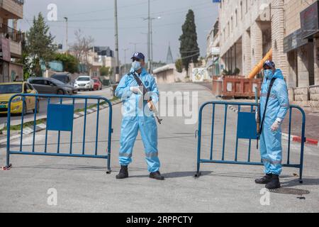 200315 -- BETHLÉEM, le 15 mars 2020 -- des policiers palestiniens portant des vêtements de protection montent la garde près d'une zone de quarantaine dans la ville de Bethléem en Cisjordanie le 15 mars 2020. Samedi, la Palestine a signalé trois nouveaux cas de COVID-19, portant le total des cas confirmés du pays à 38. Photo Luay Sababa/Xinhua MIDEAST-BETHLEHEM-COVID-19 xiongsihao PUBLICATIONxNOTxINxCHN Banque D'Images