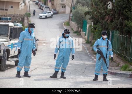 200315 -- BETHLÉEM, le 15 mars 2020 -- des policiers palestiniens portant des vêtements de protection montent la garde près d'une zone de quarantaine dans la ville de Bethléem en Cisjordanie le 15 mars 2020. Samedi, la Palestine a signalé trois nouveaux cas de COVID-19, portant le total des cas confirmés du pays à 38. Photo Luay Sababa/Xinhua MIDEAST-BETHLEHEM-COVID-19 xiongsihao PUBLICATIONxNOTxINxCHN Banque D'Images