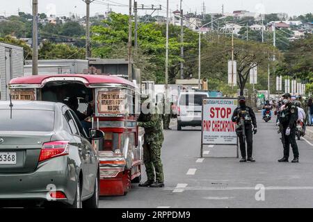 200316 -- QUEZON CITY, le 16 mars 2020 -- des policiers de la PNP de la police nationale philippine inspectent des personnes à un poste de contrôle à Quezon City, aux Philippines, le 16 mars 2020. Le président philippin Rodrigo Duterte a placé toute l’île principale de Luzon aux Philippines sous quarantaine communautaire renforcée dans une tentative drastique de contenir la propagation du COVID-19 dans le pays, a déclaré lundi le porte-parole du président Salvador Panelo. Les Philippines ont maintenant 140 cas confirmés de COVID-19, dont 12 décès. PHILIPPINES-QUEZON VILLE-COMMUNAUTÉ QUARANTAINE ROUELLExUMALI PUBLICATIONxNOTxINxCHN Banque D'Images