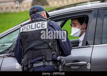 200317 -- PARIS, le 17 mars 2020 Xinhua -- Un policier vérifie une voiture sur l'avenue des champs-Elysées à Paris, France, le 17 mars 2020. La France a détecté 7 730 cas d’infection à coronavirus, et 175 personnes sont mortes du virus, a annoncé mardi le directeur général de la Santé Jérôme Salomon lors d’une mise à jour quotidienne. Mardi midi, la France a été mise en confinement pendant au moins 15 jours. Seuls les voyages réellement nécessaires, par exemple pour des raisons professionnelles ou de santé ou pour acheter des aliments, sont autorisés. Photo Aurelien Morissard/Xinhua FRANCE-PARIS-COVID-19-LOCKDOWN PUBLICATIONxNOTxINxCHN Banque D'Images
