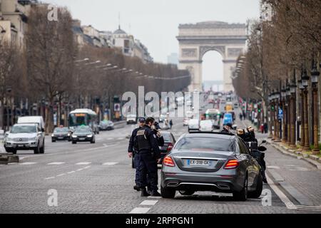 200317 -- PARIS, le 17 mars 2020 Xinhua -- des policiers vérifient des voitures sur l'avenue des champs-Elysées à Paris, France, le 17 mars 2020. La France a détecté 7 730 cas d’infection à coronavirus, et 175 personnes sont mortes du virus, a annoncé mardi le directeur général de la Santé Jérôme Salomon lors d’une mise à jour quotidienne. Mardi midi, la France a été mise en confinement pendant au moins 15 jours. Seuls les voyages réellement nécessaires, par exemple pour des raisons professionnelles ou de santé ou pour acheter des aliments, sont autorisés. Photo Aurelien Morissard/Xinhua FRANCE-PARIS-COVID-19-LOCKDOWN PUBLICATIONxNOTxINxCHN Banque D'Images