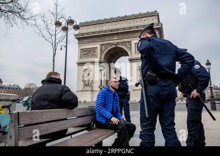 200317 -- PARIS, le 17 mars 2020 Xinhua -- des policiers vérifient les piétons près de l'Arc de Triomphe à Paris, France, le 17 mars 2020. La France a détecté 7 730 cas d’infection à coronavirus, et 175 personnes sont mortes du virus, a annoncé mardi le directeur général de la Santé Jérôme Salomon lors d’une mise à jour quotidienne. Mardi midi, la France a été mise en confinement pendant au moins 15 jours. Seuls les voyages réellement nécessaires, par exemple pour des raisons professionnelles ou de santé ou pour acheter des aliments, sont autorisés. Photo Aurelien Morissard/Xinhua FRANCE-PARIS-COVID-19-LOCKDOWN PUBLICATIONxNOTxINxCHN Banque D'Images