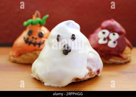 Trois des croissants glacés de sucre en forme de Ghosts d'Halloween sur fond en bois Banque D'Images