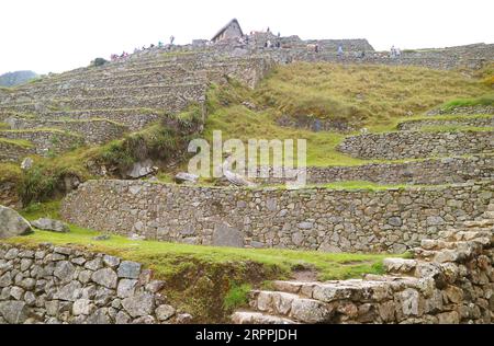 Groupe de visiteurs explorant les anciennes ruines incas de Machu Picchu, site du patrimoine mondial de l'UNESCO dans la région de Cusco au Pérou, Amérique du Sud Banque D'Images