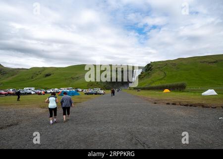 Skogafoss, Islande - 8 juillet 2023 : court sentier pédestre jusqu'à la cascade de Skogafoss, traverse un terrain de camping Banque D'Images