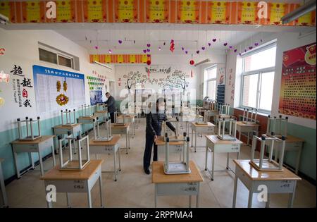 200319 -- TAIYUAN, le 19 mars 2020 -- le personnel organise des tables et des chaises dans une salle de classe d'une école à Taiyuan, capitale de la province du Shanxi du nord de la Chine, le 19 mars 2020. Les élèves de troisième année des écoles secondaires de la province du Shanxi commenceront leur nouveau semestre le 25 mars, les écoles préparant pleinement leur nouveau trimestre. CHINE-SHANXI-NOUVEAU SEMESTRE-PRÉPARATION CN YANGXCHENGUANG PUBLICATIONXNOTXINXCHN Banque D'Images