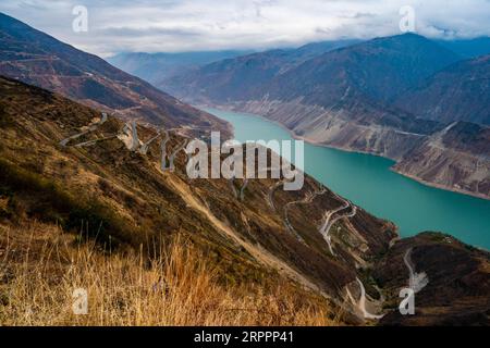 200320 -- KUNMING, le 20 mars 2020 -- des véhicules de relocalisation roulent sur une route sinueuse vers la zone de réinstallation de Maojiawan pour les pauvres dans le comté de Ludian, dans la province du Yunnan au sud-ouest de la Chine, le 15 mars 2020. Niché au cœur des montagnes de la province du Yunnan du sud-ouest de la Chine, le village de Luoqiu abrite seulement des dizaines de ménages dispersés dans la vallée montagneuse. Le villageois Yan Fugao et sa femme Wang Daxiang vivent ici depuis plus de 20 ans. Le rude environnement montagneux ici a sévèrement restreint les activités économiques des populations locales et a causé la pauvreté de certaines d entre elles. La famille de Yan Fugao est parmi eux, Banque D'Images