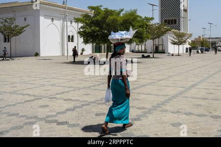 200320 -- DAKAR, le 20 mars 2020 Xinhua -- Une femme vend de l'eau sur une place presque vide à Dakar, au Sénégal, le 20 mars 2020. Le ministre sénégalais de la Santé et de l’action sociale Abdoulaye Sarr a annoncé vendredi soir que neuf nouveaux cas confirmés du nouveau coronavirus COVID-19 ont été détectés au Sénégal. À ce jour, le Sénégal a signalé 47 cas de COVID-19. Cinq patients ont été déclarés guéris par les autorités sanitaires locales. Photo Eddy Peters/Xinhua SÉNÉGAL-DAKAR-COVID-19-CAS PUBLICATIONxNOTxINxCHN Banque D'Images