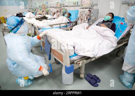 200321 -- WUHAN, le 21 mars 2020 -- des travailleurs médicaux effectuent un traitement d'hémodialyse pour un patient urémique se rétablissant d'une infection par le COVID-19 à l'hôpital Hankou à Wuhan, capitale de la province du Hubei en Chine centrale, le 21 mars 2020. Les médecins du centre d’hémodialyse du département de néphrologie de l’hôpital Hankou ont maintenu leur poste pendant la nouvelle épidémie de coronavirus. En plus d’effectuer un traitement de purification du sang pour les patients atteints de COVID-19 dans des conditions critiques, ils effectuent également un traitement d’hémodialyse pour quelque 40 patients urémiques se rétablissant de l’infection COVID-19 ev Banque D'Images