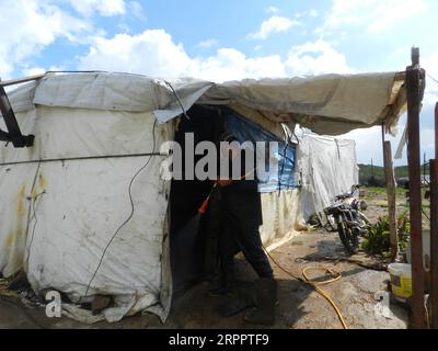 200322 -- BEYROUTH, le 22 mars 2020 Xinhua -- Un homme désinfecte un camp de réfugiés syriens dans le sud du Liban le 21 mars 2020. Les camps et les maisons de réfugiés syriens dans le sud du Liban ont été désinfectés samedi par les autorités locales. Le nombre de cas de COVID-19 au Liban a augmenté samedi à 206, a rapporté l Agence nationale de presse, citant le ministère de la Santé. Photo Taher/Xinhua LIBAN-BEYROUTH-CAMPS DE RÉFUGIÉS-DÉSINFECTION PUBLICATIONxNOTxINxCHN Banque D'Images