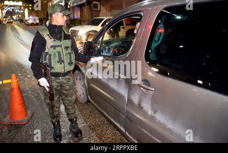 200323 -- HÉBRON, le 23 mars 2020 Xinhua -- Un policier palestinien parle à un chauffeur à un poste de contrôle à l'entrée de la ville de Hébron en Cisjordanie le 22 mars 2020. Les autorités palestiniennes ont déclaré dimanche un confinement de 14 jours en Cisjordanie dans le cadre des mesures visant à lutter contre la propagation de la pandémie de coronavirus. Photo de Mamoun Wazwaz/Xinhua MIDEAST-HEBRON-COVID-19-LOCKDOWN PUBLICATIONxNOTxINxCHN Banque D'Images