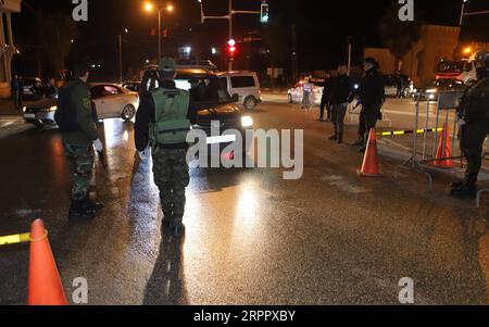 200323 -- HÉBRON, le 23 mars 2020 Xinhua -- des policiers palestiniens montent la garde à un poste de contrôle à l'entrée de la ville d'Hébron en Cisjordanie pour maintenir l'ordre public, le 22 mars 2020. Les autorités palestiniennes ont déclaré dimanche un confinement de 14 jours en Cisjordanie dans le cadre des mesures visant à lutter contre la propagation de la pandémie de coronavirus. Photo de Mamoun Wazwaz/Xinhua MIDEAST-HEBRON-COVID-19-LOCKDOWN PUBLICATIONxNOTxINxCHN Banque D'Images