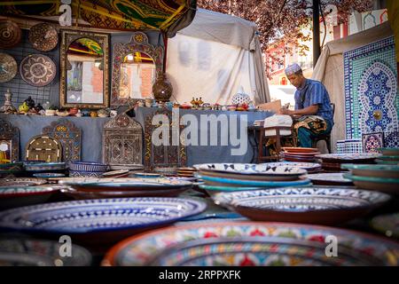 Atelier artisanal marocain, avec ouvrier en arrière-plan, entouré de leurs produits. Photographie prise le 2 septembre 2023 dans la ville d'AV Banque D'Images