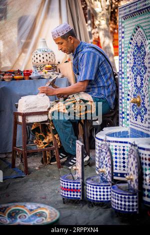 Atelier artisanal marocain, avec ouvrier en arrière-plan, entouré de leurs produits. Photographie prise le 2 septembre 2023 dans la ville d'AV Banque D'Images