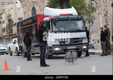 200323 -- HÉBRON, le 23 mars 2020 -- Un policier palestinien parle à un chauffeur à un poste de contrôle à l'entrée de la ville de Hébron en Cisjordanie, le 23 mars 2020. Les autorités palestiniennes ont déclaré dimanche un confinement de 14 jours en Cisjordanie dans le cadre des mesures visant à lutter contre la propagation de la pandémie de coronavirus. Le Premier ministre Mohammed Ishtaye a annoncé une interdiction des transports et des déplacements entre les districts de Cisjordanie, exhortant les citoyens à rester chez eux. Photo de Mamoun Wazwaz/Xinhua MIDEAST-HEBRON-COVID-19-MEASURES XiongxSihao PUBLICATIONxNOTxINxCHN Banque D'Images