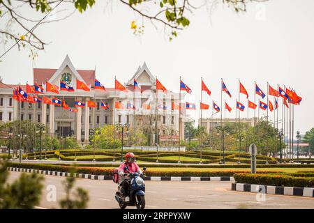 200323 -- VIENTIANE, le 23 mars 2020 -- une photo prise le 23 mars 2020 montre des drapeaux nationaux lao et des drapeaux du Parti révolutionnaire populaire lao LPRP devant le bureau du Premier ministre à Vientiane, au Laos. Le 22 mars 2020 marque le 65e anniversaire de la création du parti. Photo Kaikeo Saiyasane/Xinhua LAOS-VIENTIANE-LPRP-65E ANNIVERSAIRE ZhangxJianhua PUBLICATIONxNOTxINxCHN Banque D'Images