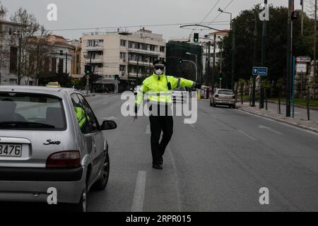 200323 -- ATHÈNES, le 23 mars 2020 -- Un policier arrête une voiture pour vérifier des documents à Athènes, en Grèce, le 23 mars 2020. Les rues des villes de Grèce ont été désertées lorsque le gouvernement a lancé lundi un confinement national de 14 jours dans le but de contenir la propagation du COVID-19. La Grèce a enregistré à ce jour 17 décès liés au COVID-19, contre 15 signalés la veille et 71 nouveaux cas confirmés, ce qui porte le total à 695. Photo de /Xinhua GREECE- ATHENS-COVID19-LOCKDOWN LEFTERISxPARTSALIS PUBLICATIONxNOTxINxCHN Banque D'Images