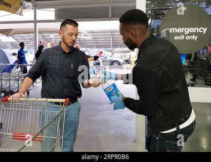 200324 -- JOHANNESBURG, le 24 mars 2020 -- un membre du personnel désinfecte les mains d'un client dans un supermarché à Johannesburg, en Afrique du Sud, le 23 mars 2020. Alors que les cas de COVID-19 ont passé la barre des 400 lundi, le président sud-africain Cyril Ramaphosa a déclaré qu’un confinement à l’échelle du pays serait mis en œuvre jeudi. Le confinement de 21 jours durerait jusqu’au 16 avril, a annoncé le président à Pretoria. AFRIQUE DU SUD-JOHANNESBURG-COVID-19 ChenxCheng PUBLICATIONxNOTxINxCHN Banque D'Images